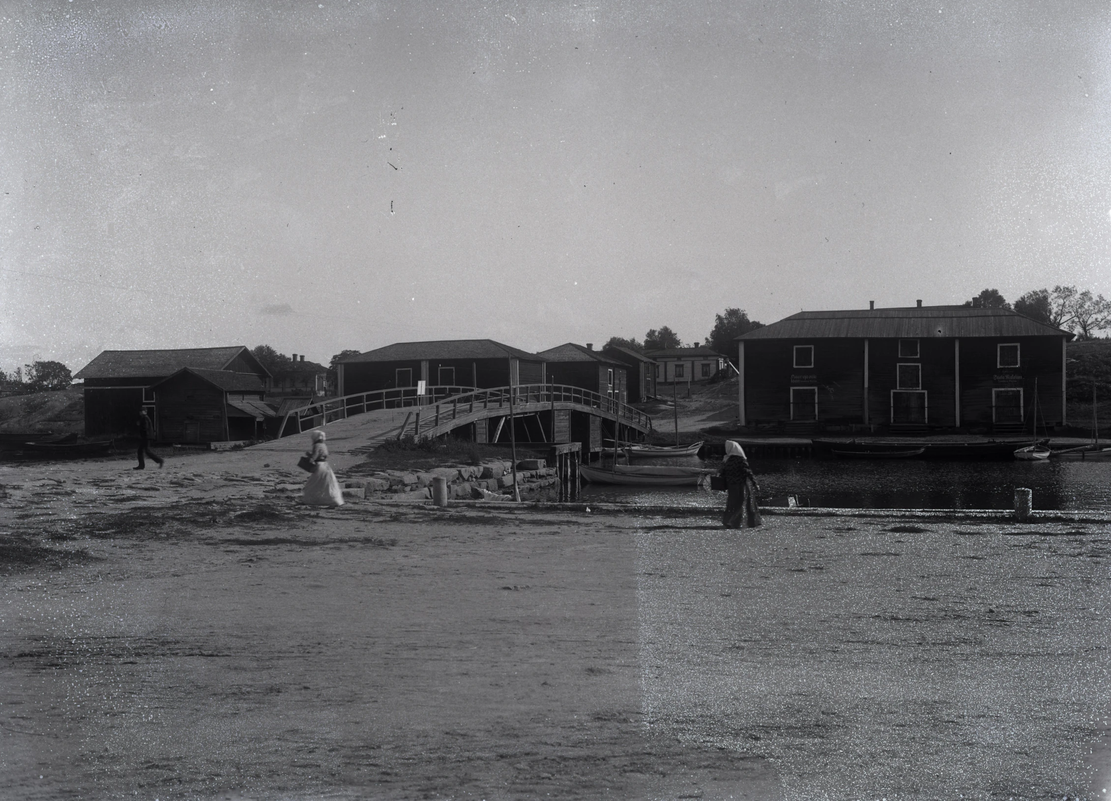 an old black and white po with people by the water