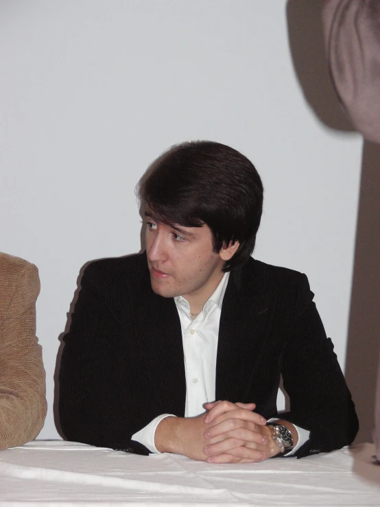 a man in black jacket sitting at table