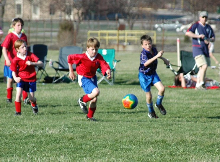 boys running after a soccer ball in a field