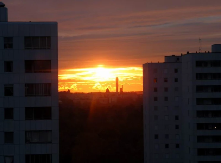 the sun rises over a city in the distance