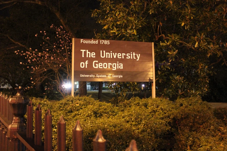 the university of georgia sign at night is lit up