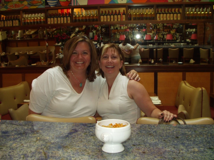 two women sitting in front of an eating table