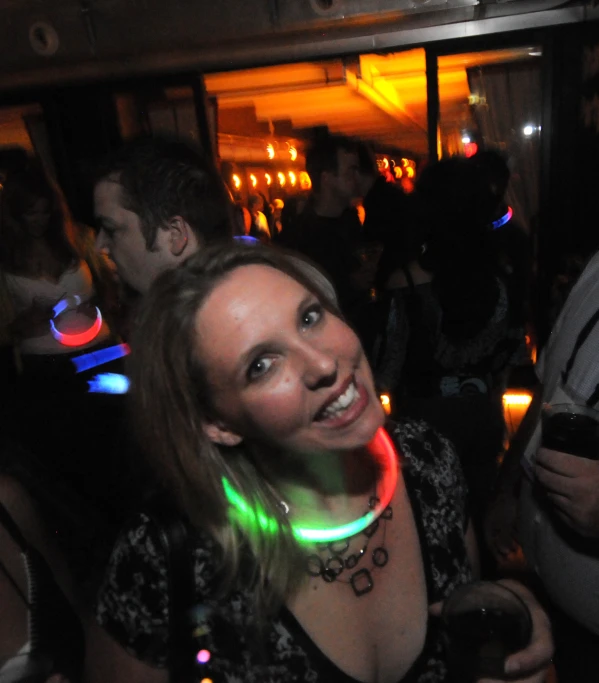 the woman wearing an interesting neon necklace smiles at the camera