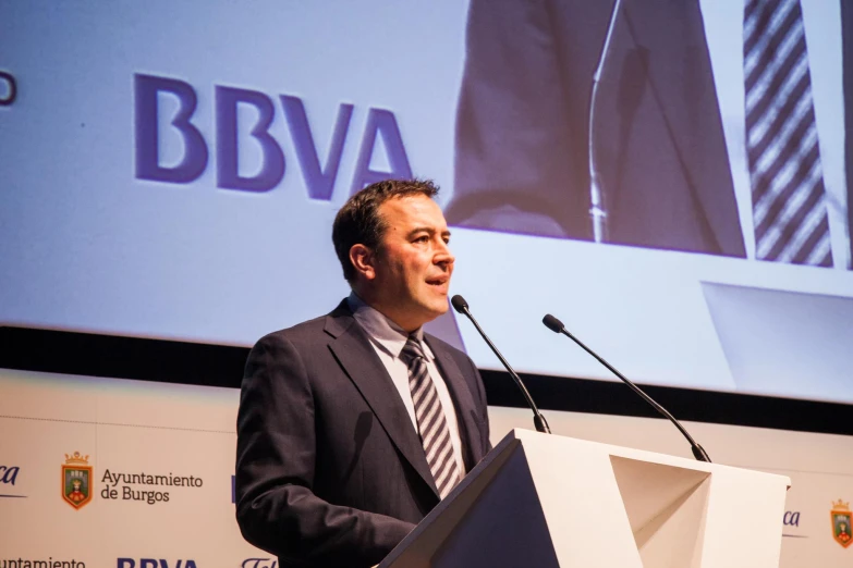 a man stands behind a podium and gives a speech