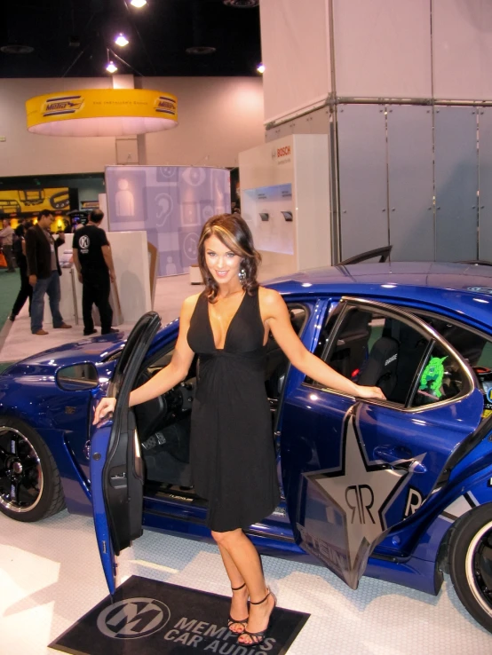 a woman standing with her car open at show