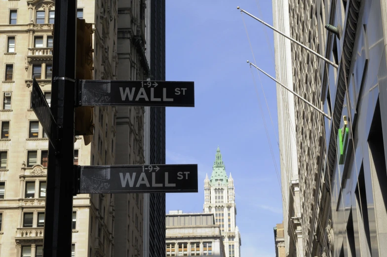 two black signs are hanging from the pole of the street