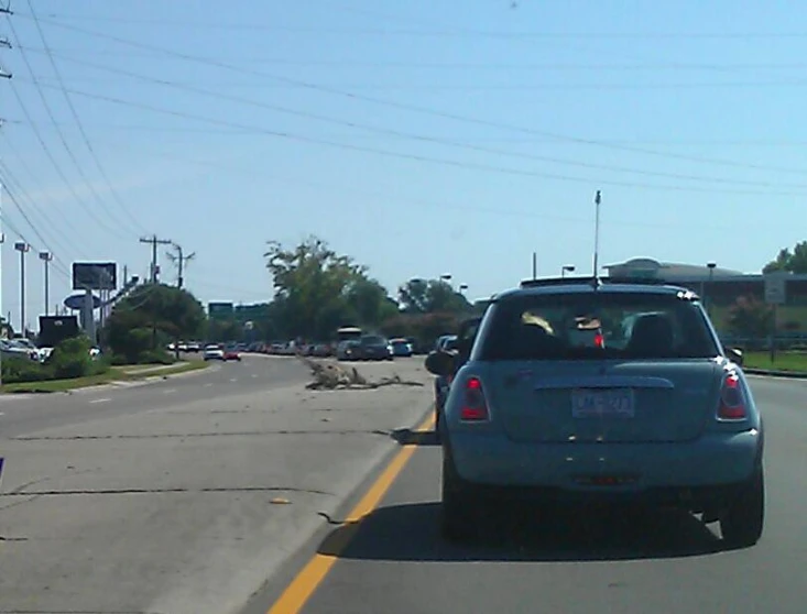 a blue car driving down the street in traffic