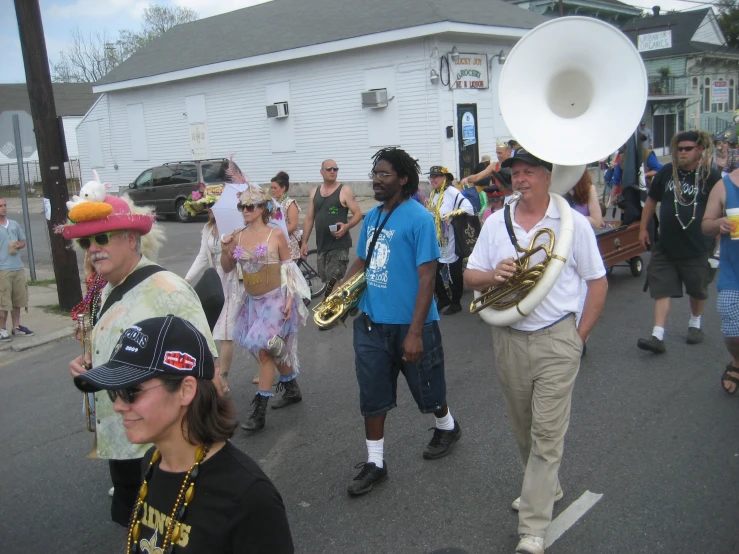 a crowd of people are walking down the street with large instruments