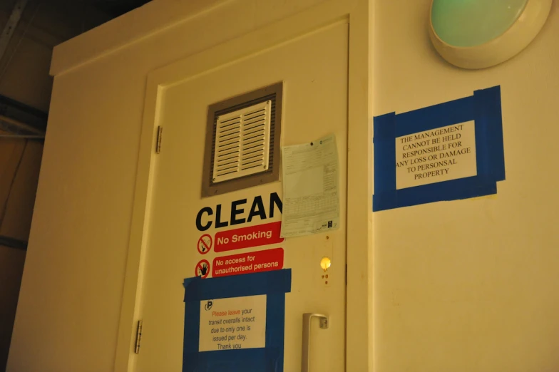 a bathroom door with a bunch of signs hanging on the side of it