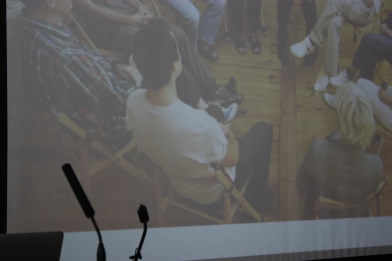 a person with a microphone in front of a large screen