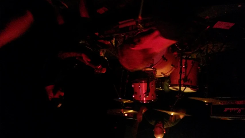 three drummers in a black background playing music