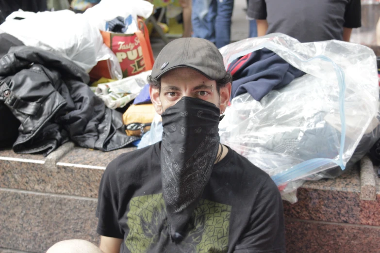 a man wearing a face mask surrounded by piles of trash