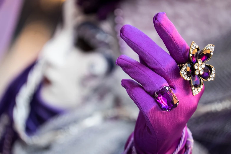 there is purple gloves with a hand with a ring