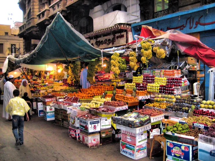 people walking around fruit stands and street vendors