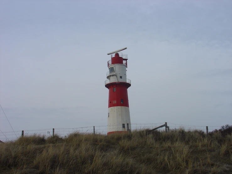 a large lighthouse with lights on is standing out in the field