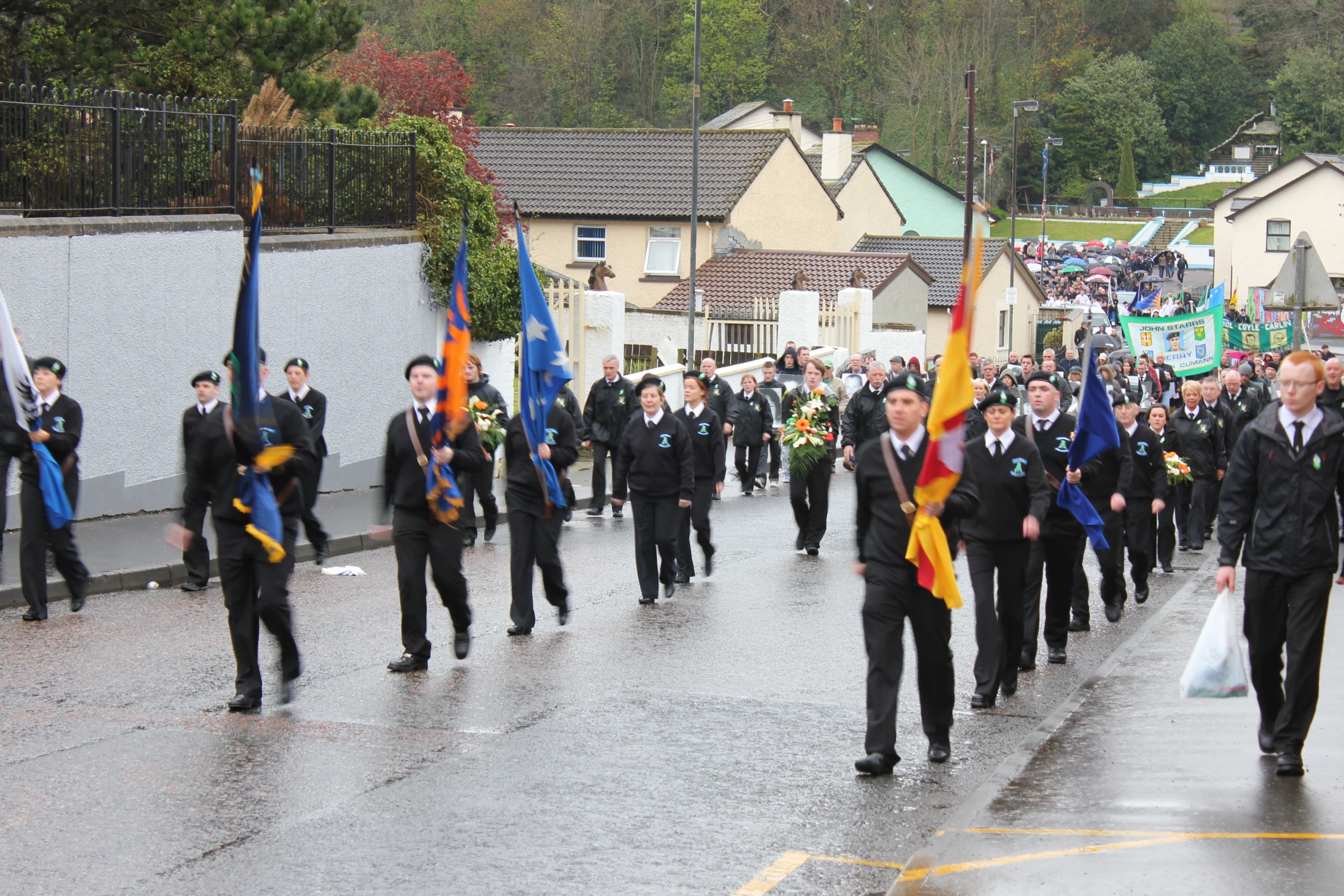 a group of men walking down a street carrying flags