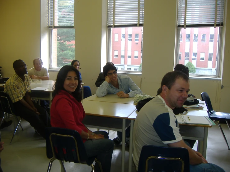 people are seated in chairs around tables