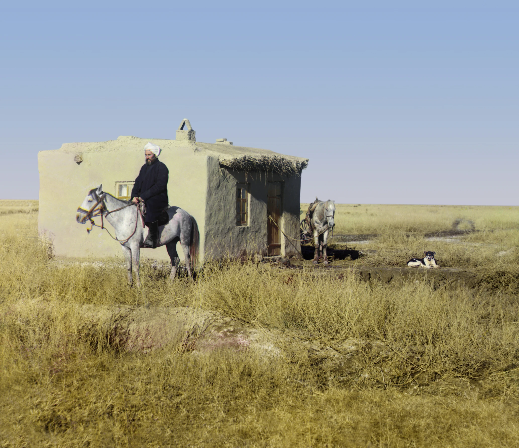 a man on horse next to an old building