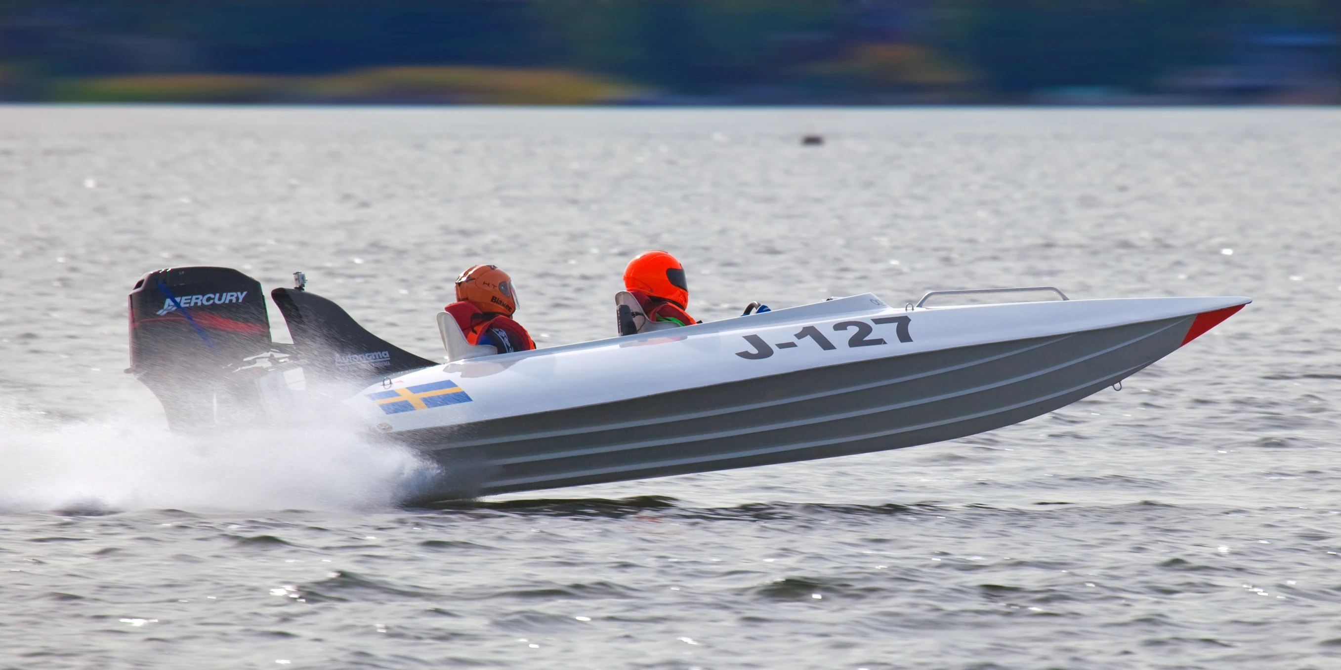 a speed boat speeds through the water with a number of sailors