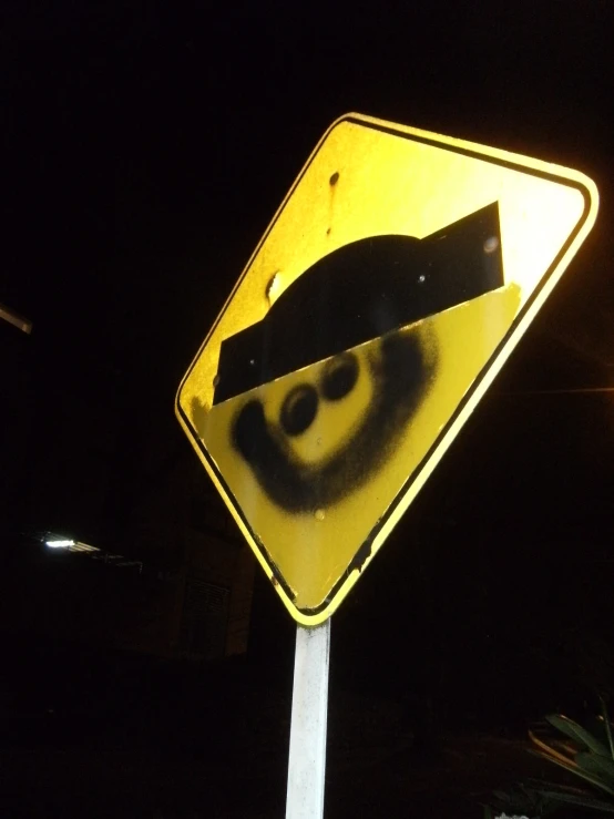 a yellow traffic sign is posted on a pole