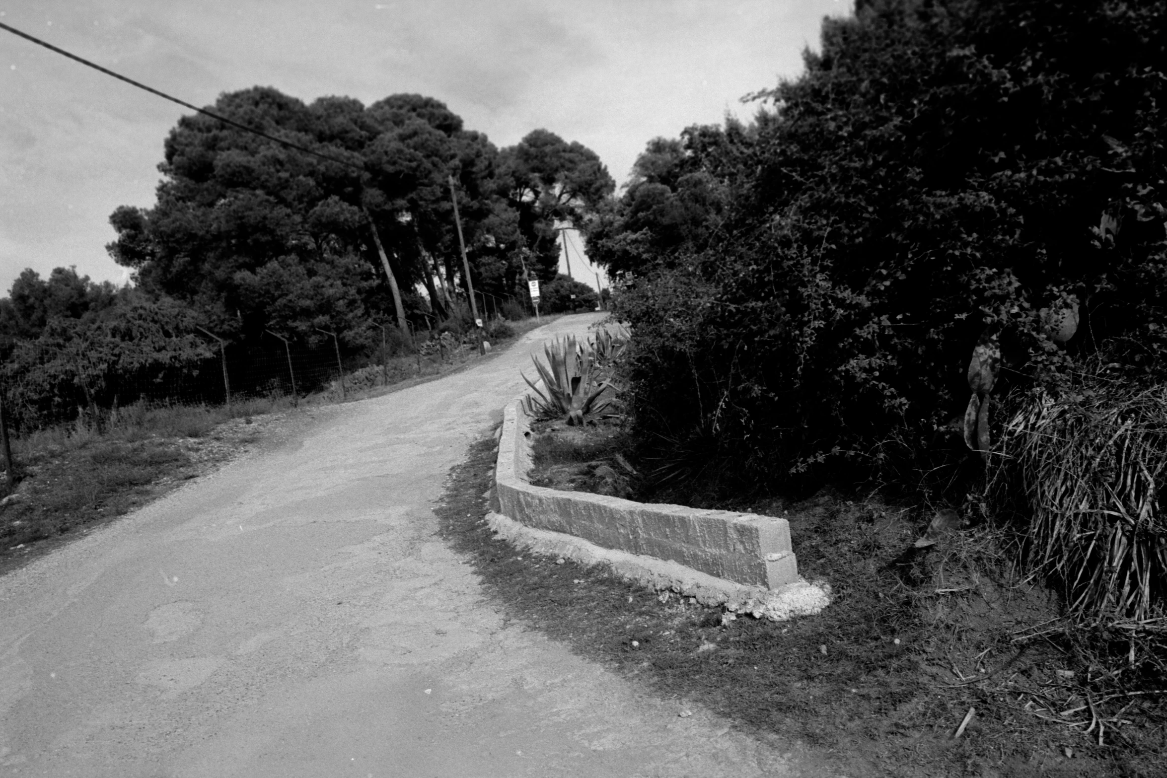 a long concrete bench sitting on the side of a road