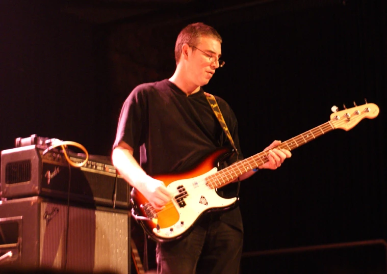 a man with glasses playing on a bass