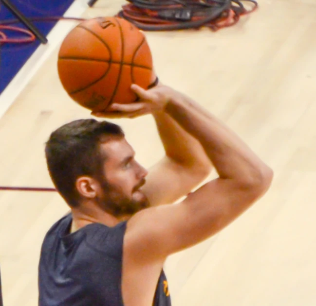 man shooting ball at basketball game being viewed from above