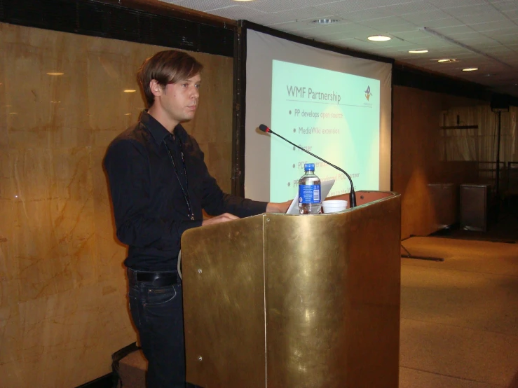 the man is standing behind the podium giving a presentation