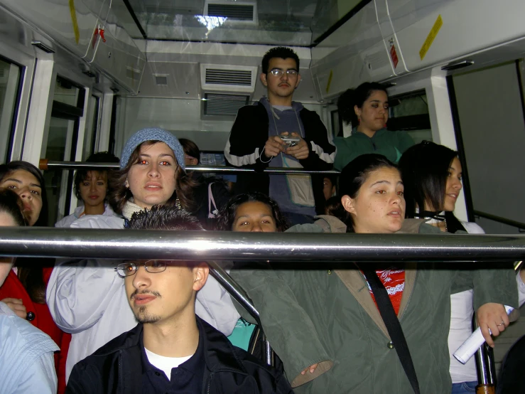 people are sitting on the subway train looking at their phones