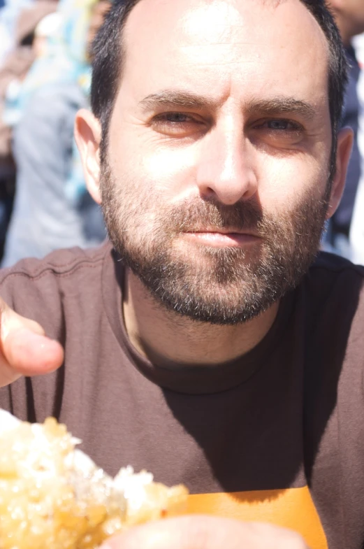 a man with a goatee holding food up