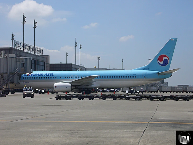 blue and white plane on runway near building