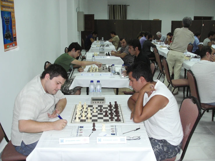 a group of men playing chess on white tile