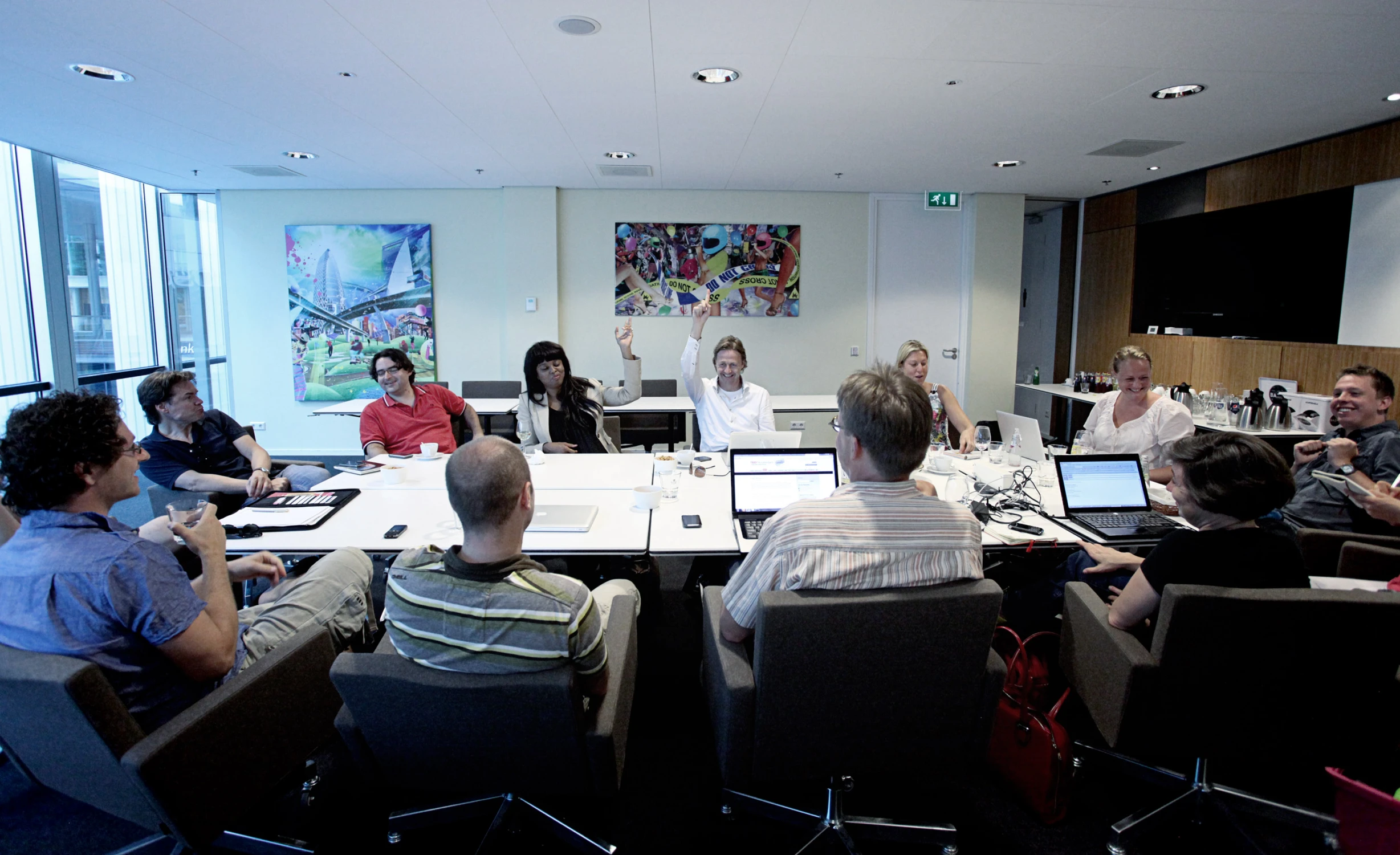 an office board room full of people all sitting around a table