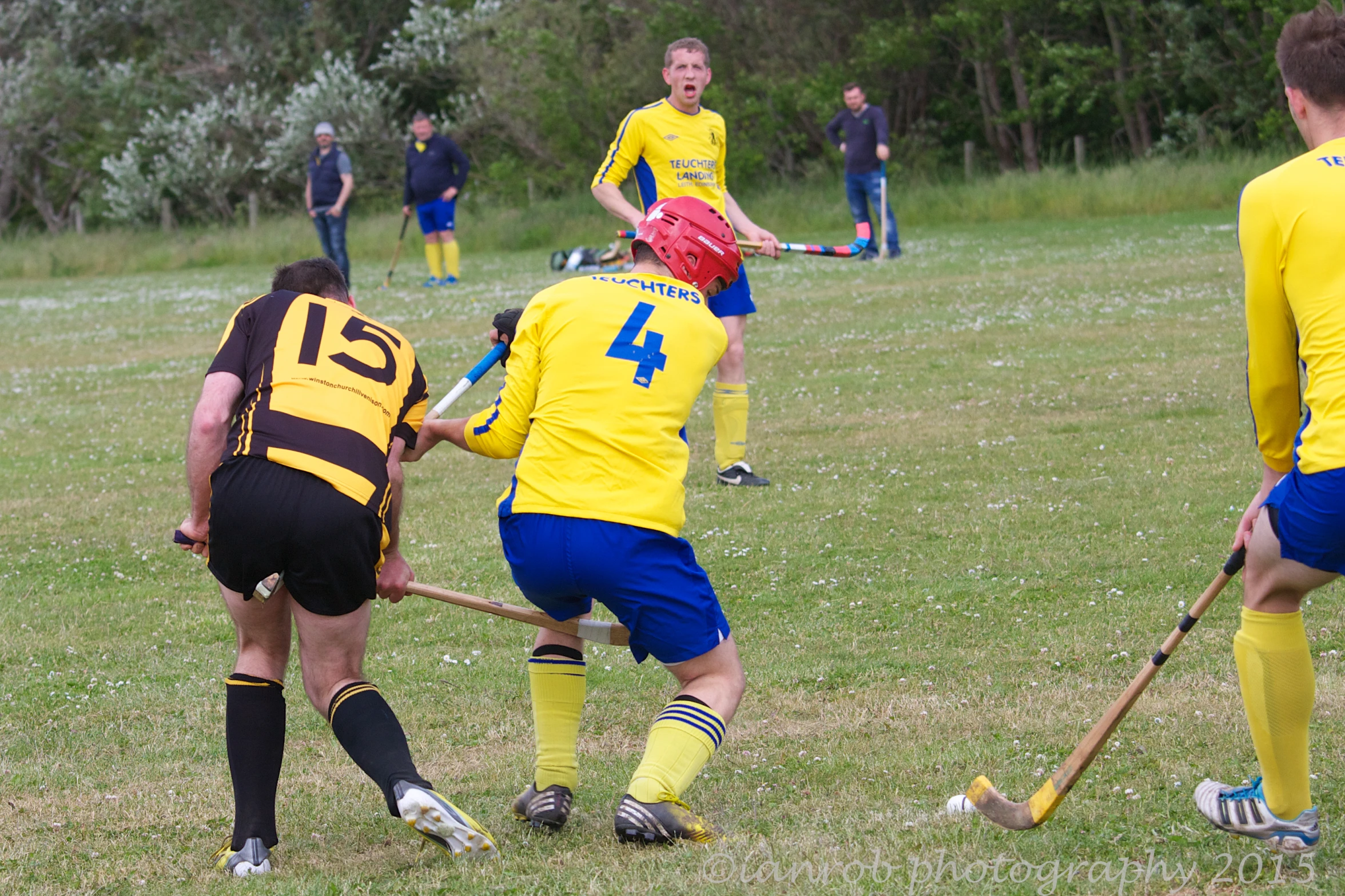 a group of boys playing soccer in yellow and blue uniforms