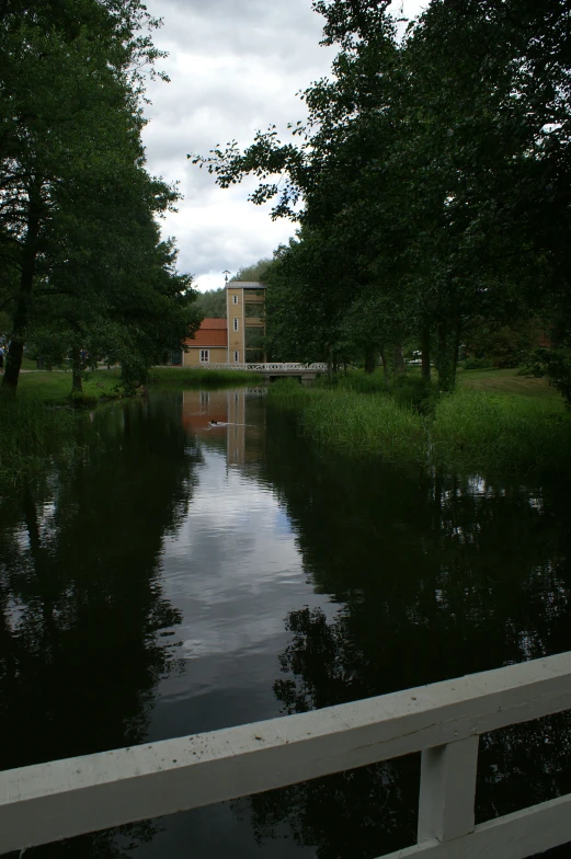 a white fence is next to a waterway