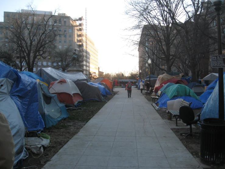 there is a sidewalk lined with a row of tents