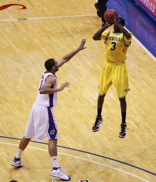 two men playing basketball as the referee watches