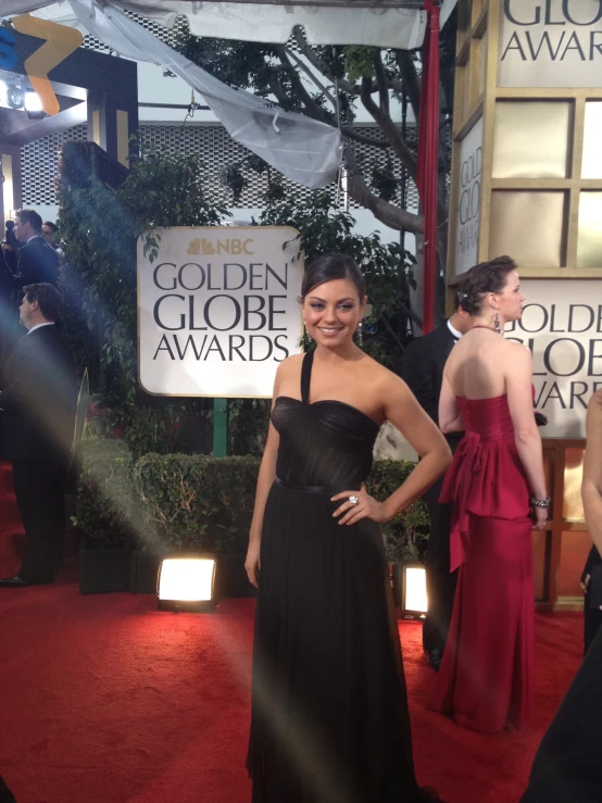 a woman wearing a black gown at an awards event