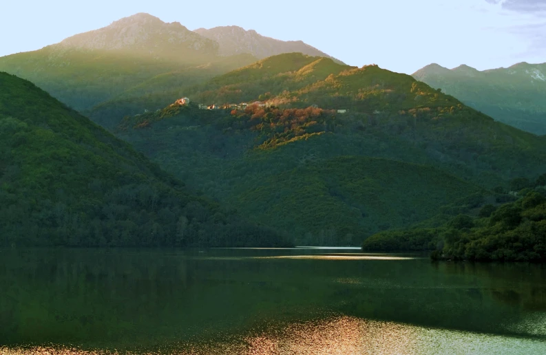 an empty lake with green mountains on both sides