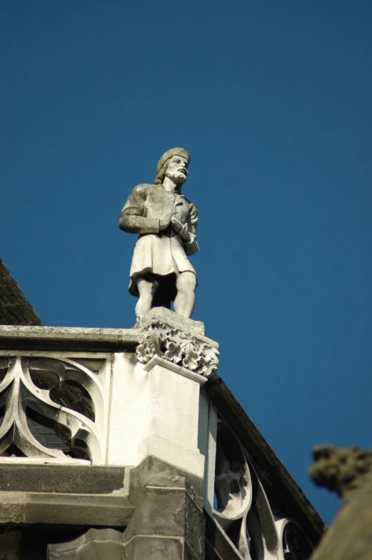 a statue is on the edge of the roof of a building