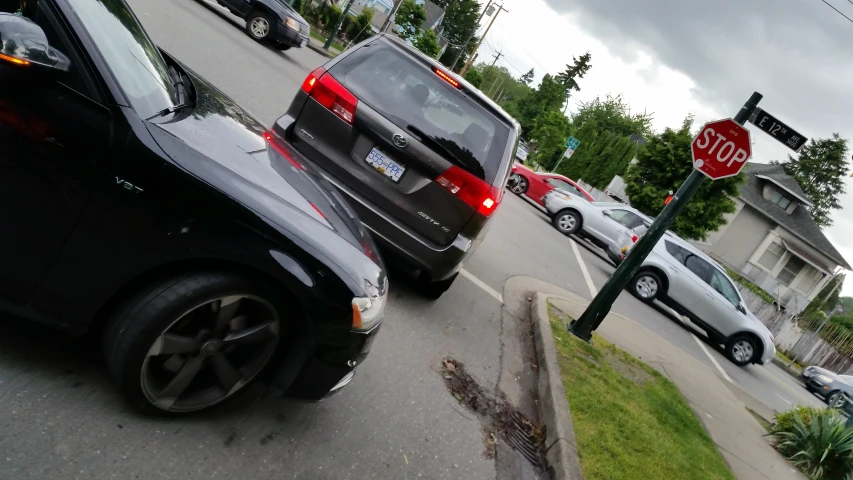 cars parked on the side of a road with stop sign