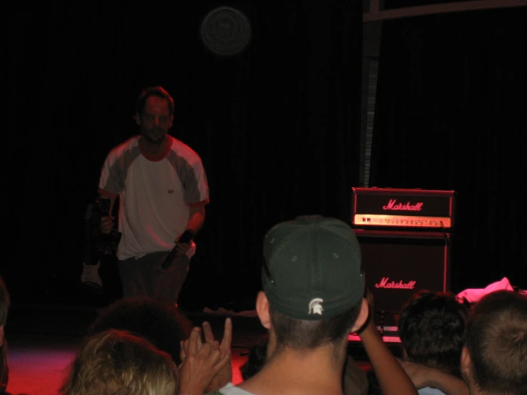 a man standing in front of a microphone on stage