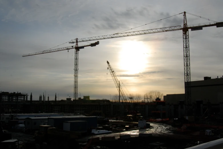 a sun over a construction site with some cranes