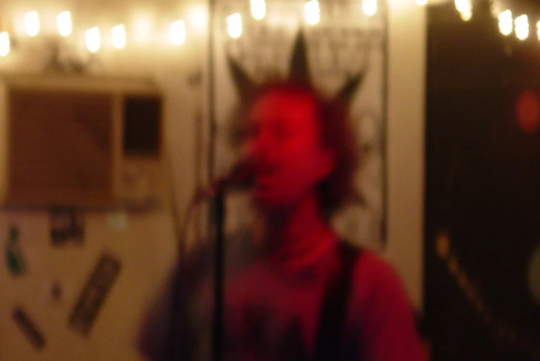 blurry image of a woman singing in front of a microphone