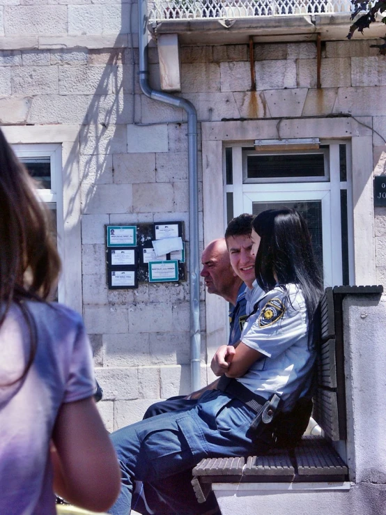 man and woman are sitting in an outside seat of a building