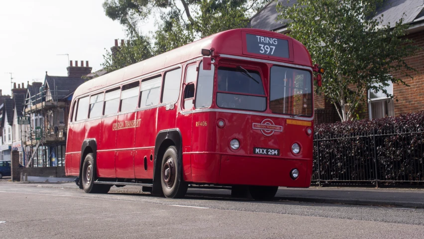 red city bus on city street in sunny day