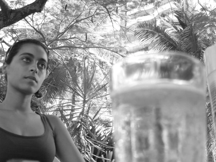 a woman with a jar full of water next to her face