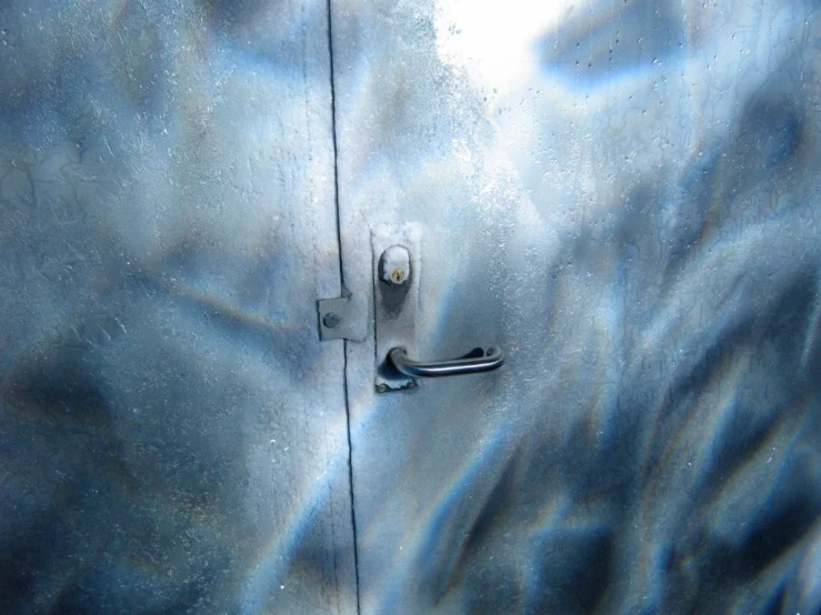 an interesting silver metallic door with handle and latch