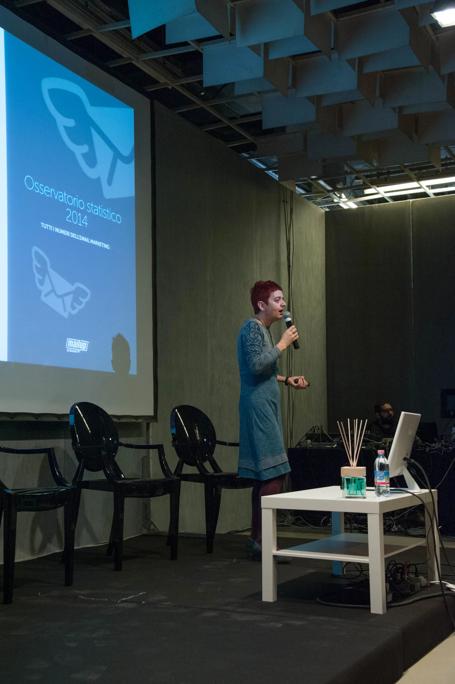 a person standing on a stage holding a cup