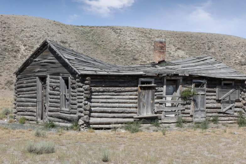 a old, rustic log house with a chimney